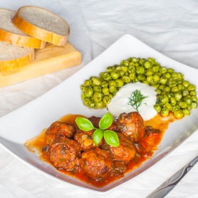 Meatballs in tomato sauce with sauteed peas